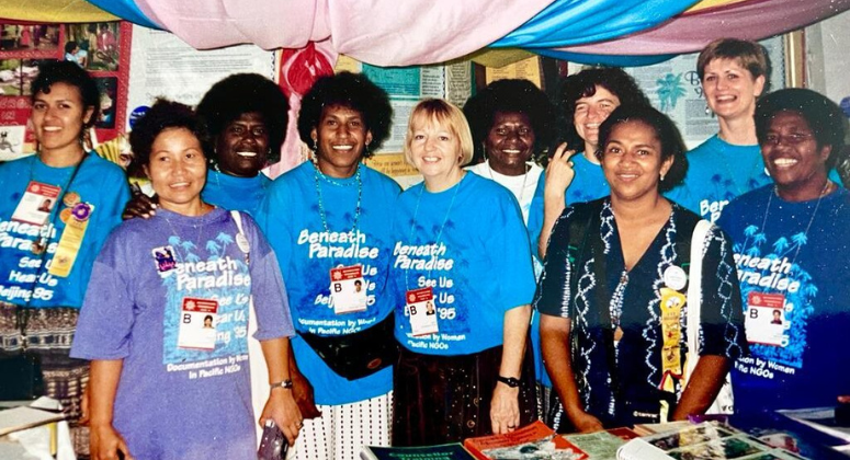 Women wearing brightly coloured headscarves look away from the camera.