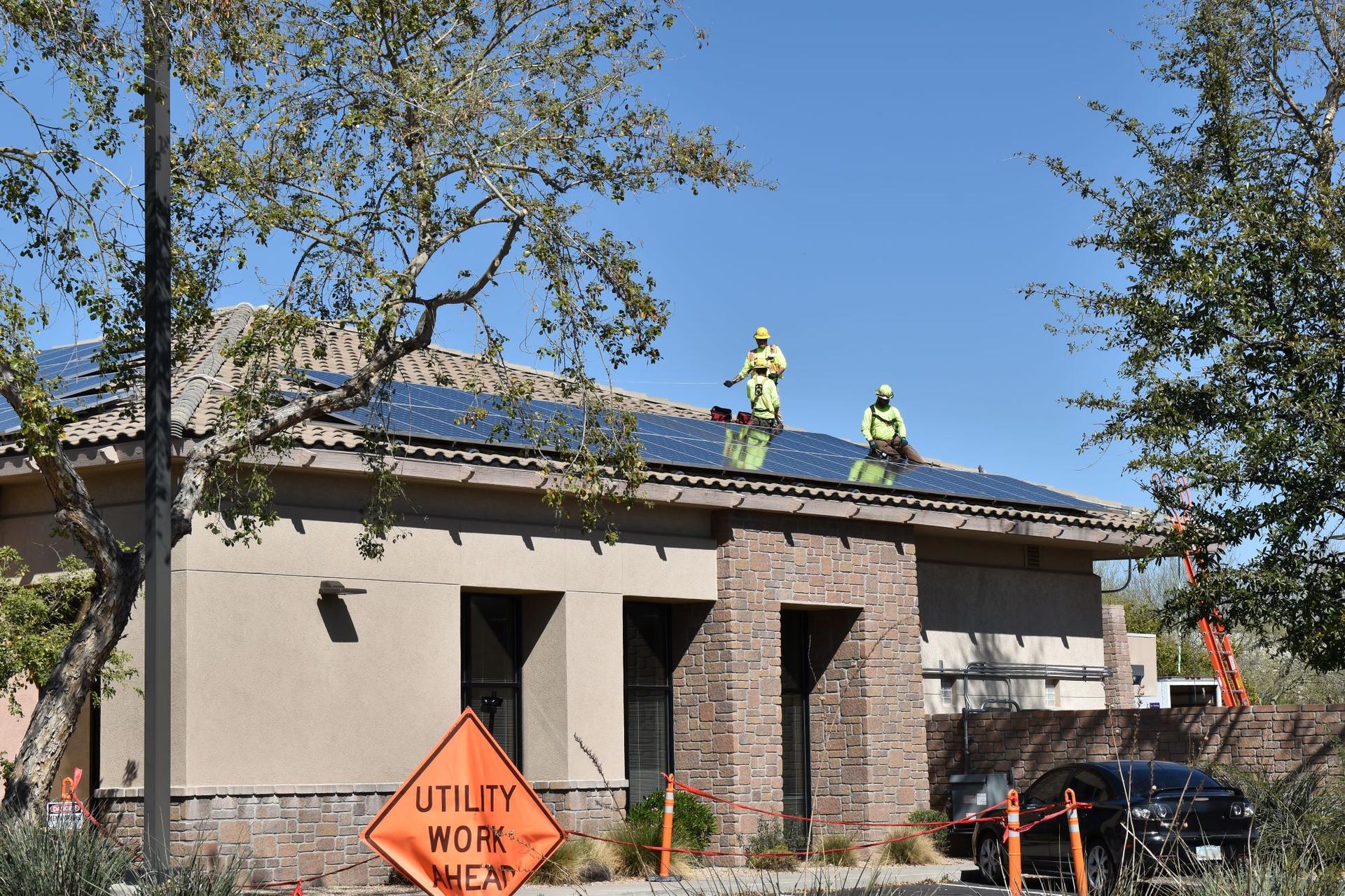 People installing solar panels on a roof