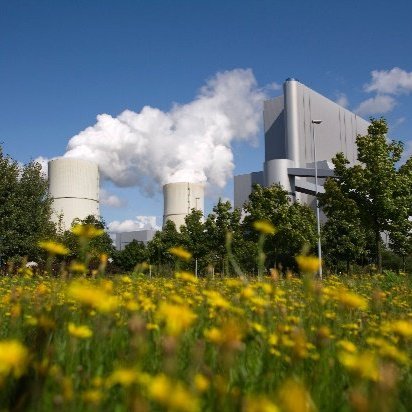 Towers bellowing steam above a field