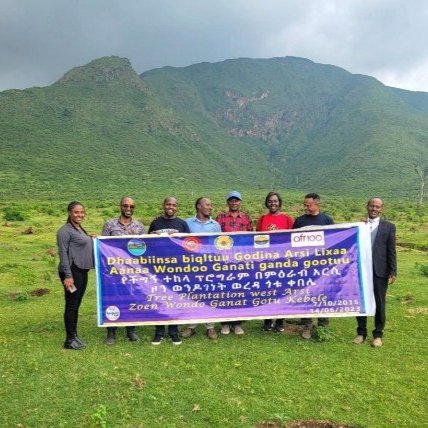 People standing with a banner in front of a mountain