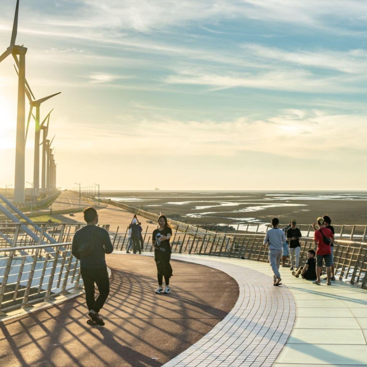 People in front of windmills