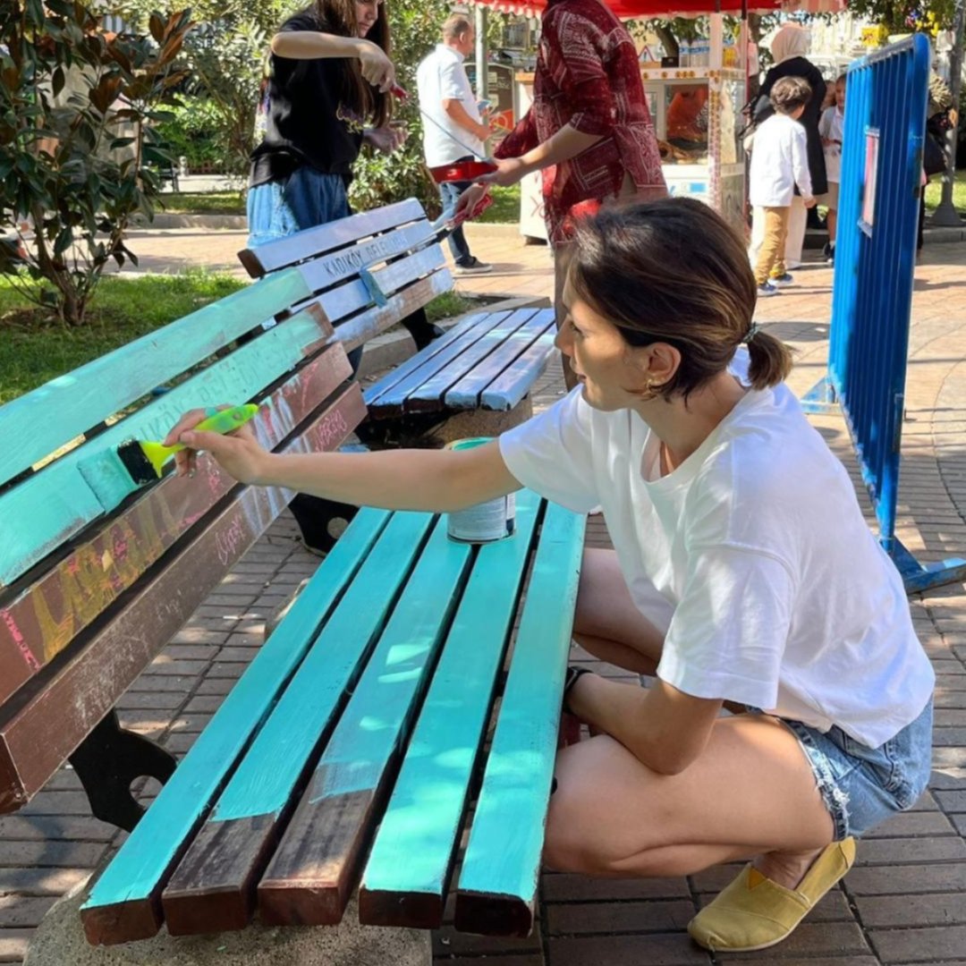 Woman painting a park bench