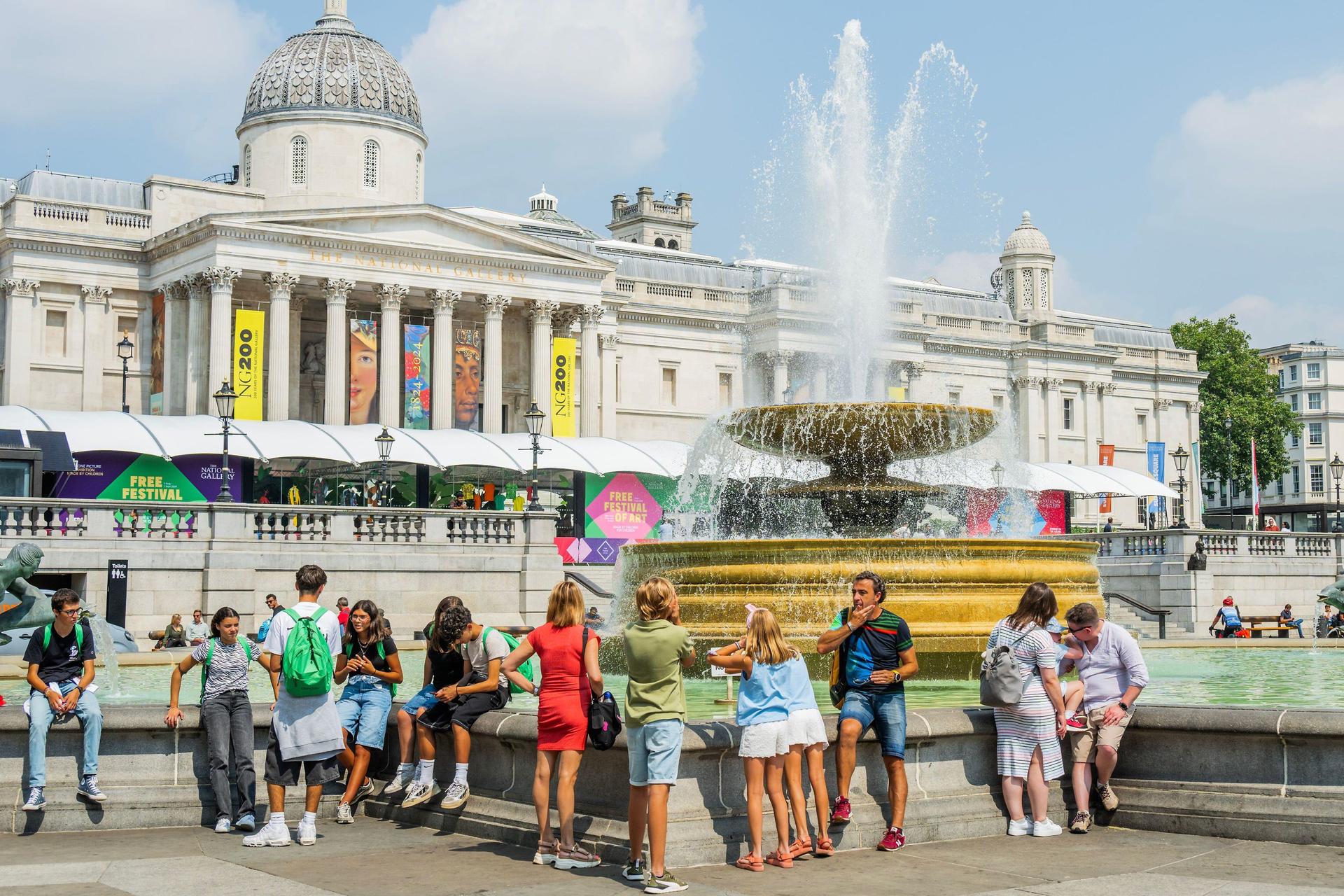 People stand near a fountain during a London heat wave.